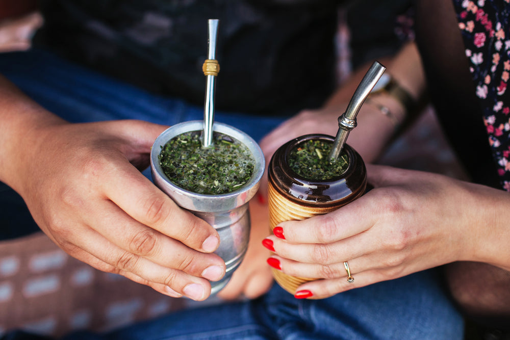 Two friends cheers with a cup of yerba mate